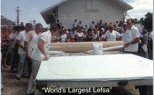 Photo of the Starbuck Lions Club members rolling out the lefse dough with a large lefse rolling pin.